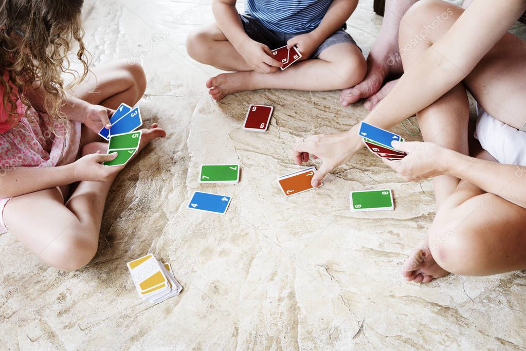 Kids playing cards on the floor