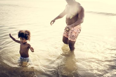 Baba ve oğul birlikte sahilde oynarken