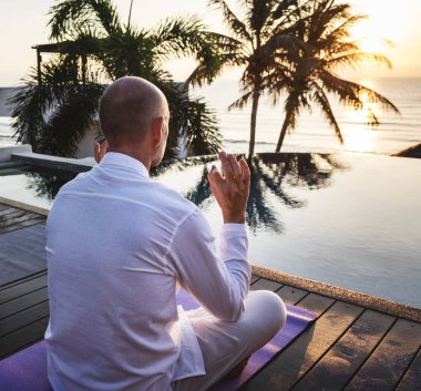 Havuzun yanında Yoga uygulamak kıdemli yetişkin