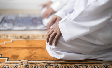 Müslüman erkeklerin dua Teşehhüt duruş, kilim üzerinde oturan insanların kırpılmış görüntü