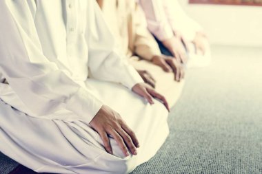 Müslüman erkeklerin dua Teşehhüt duruş, halının üzerinde oturan insanların kırpılmış görüntü