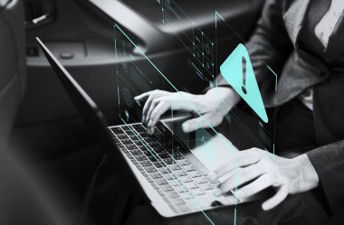 Bir arabada bir dizüstü bilgisayar üzerinde çalışan iş kadını