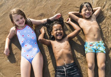 Çocuklar sahilde eğleniyor.