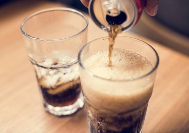 Bir cam içine soğuk kola döktü