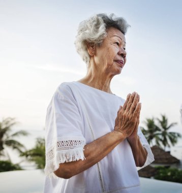 Havuzun yanında Yoga uygulamak kıdemli yetişkin