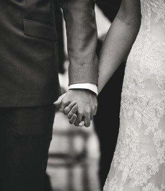 Gelin ve damat el ele tutuşuyorlar.