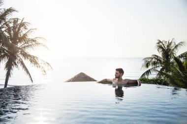 Yakışıklı adam yüzme havuzunda rahatlatıcı