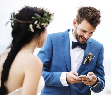 Beach düğün töreninde telefonunu kontrol damat