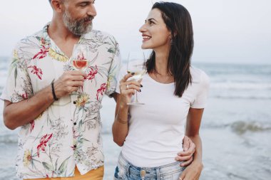 Kumsalda şarap içen çift.