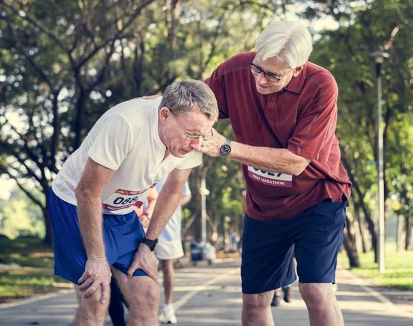 Senior Mannen Att Hjälpa Sin Vän Marathon Konkurrensen — Stockfoto