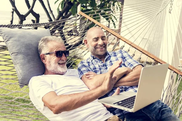 Senior Mannen Liggend Een Hangmat Met Behulp Van Een Laptop — Stockfoto
