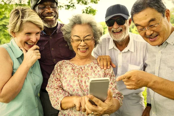 Amigos Seniores Felizes Parque Sorrindo Enquanto Navega Telefone Celular — Fotografia de Stock