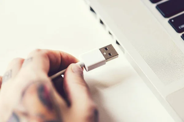 Woman connecting usb cable to laptop — 스톡 사진