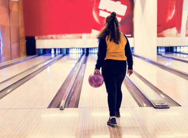ボウリングのボールの趣味やレジャーの概念をロールする女の子 — ストック写真
