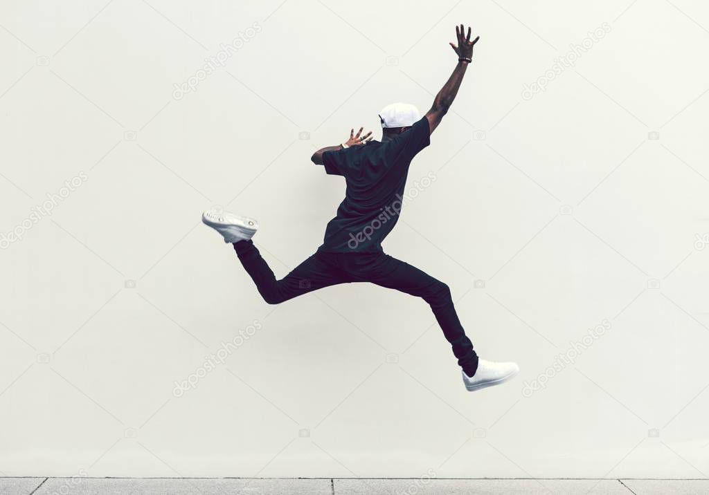 stylish african man jumping into the air