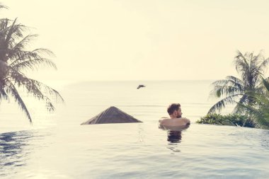 Yakışıklı adam yüzme havuzunda rahatlatıcı