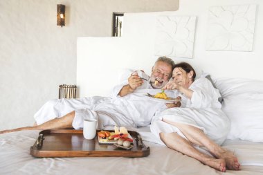 Mature couple in a luxurious hotel room clipart