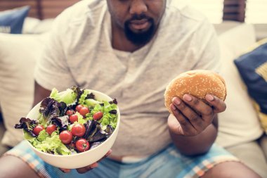 Adam büyük bir hamburger yeme