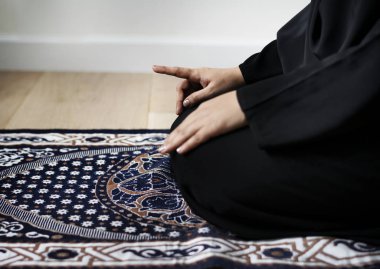 Teşehhüt Müslüman dua duruş, halıya elleriyle dizlerinin üzerinde oturan kişi kırpılmış görüntü