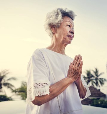 Havuzun yanında Yoga uygulamak kıdemli yetişkin