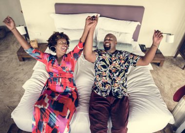African American couple relaxing on a bed clipart