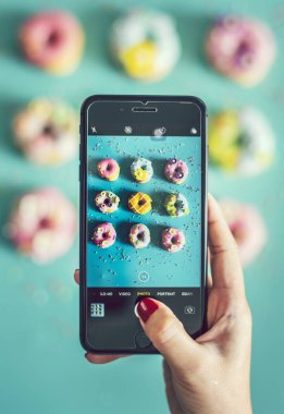Kadın alarak fotoğraf Donuts ile hareket eden telefon