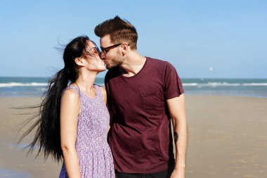 genç bir çift sahilde öpüşme