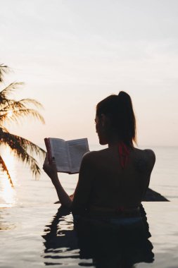 Kadın yüzme havuzunda bir kitap okuma