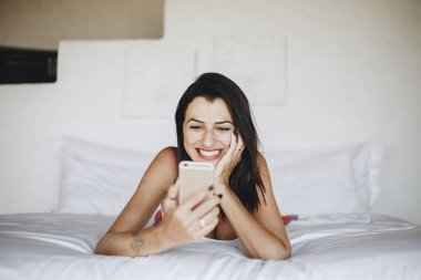 Yatakta bir cep telefonu kullanan kadın