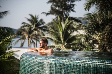 Yakışıklı adam yüzme havuzunda rahatlatıcı