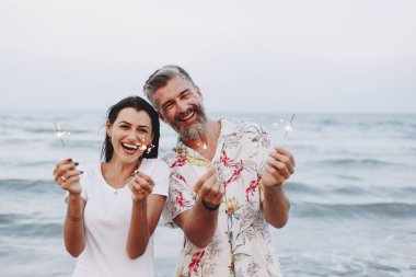 Çift sahilde havai fişekleri ile kutluyor