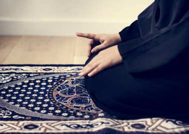 Teşehhüt Müslüman dua duruş, halıya elleriyle dizlerinin üzerinde oturan kişi kırpılmış görüntü