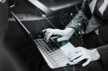 Bir arabada bir dizüstü bilgisayar üzerinde çalışan iş kadını