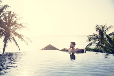 Yakışıklı adam yüzme havuzunda rahatlatıcı