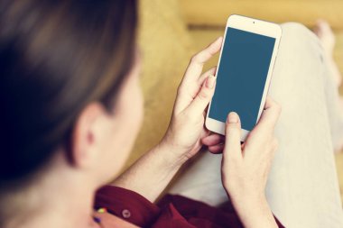 Kanepeye akıllı telefon kullanan kadın