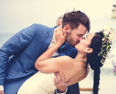 Genç çift düğün resepsiyonunda öpüşme