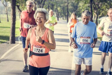 Park'ta jogging ve gülümseyen kıdemli sporcular 