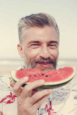 Olgun man yemek karpuz sahilde