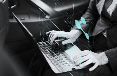 Bir arabada bir dizüstü bilgisayar üzerinde çalışan iş kadını