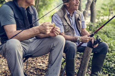 Balık tutma dal doğa holding ve küçük sandalyelere oturan iki adam 
