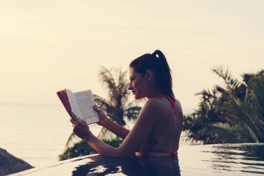 Kadın yüzme havuzunda bir kitap okuma