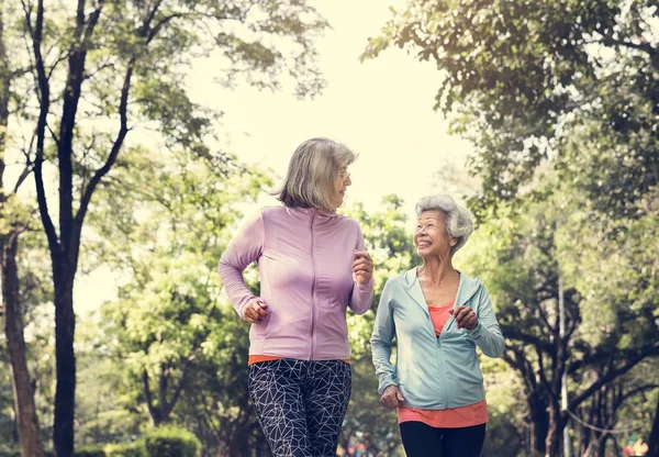 Donne Anziane Sorridenti Che Corrono Nel Parco Con Alberi Verdi — Foto Stock