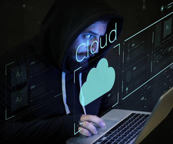 серьезный хакер, использующий ноутбук в темной комнате, рука об тачпад, неоновый текст: облако
 