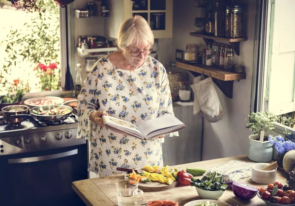 Ältere Frau Liest Der Küche Ein Kochbuch — Stockfoto
