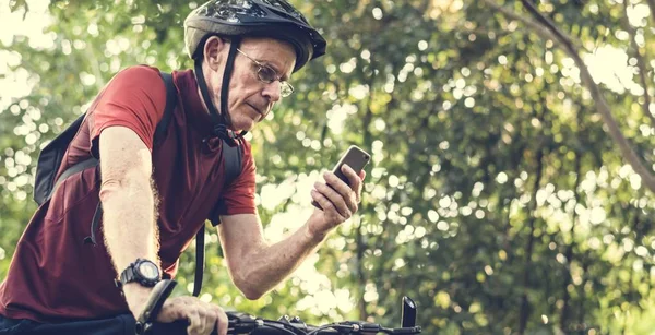 Ciclista sênior usando o GPS em seu telefone — Fotografia de Stock