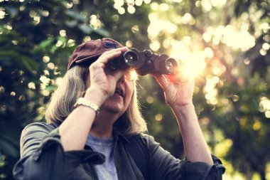 Yaşlı kadın dürbünle kuşları izlemek