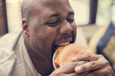 Adam büyük bir hamburger yeme