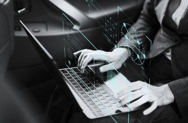 Bir arabada bir dizüstü bilgisayar üzerinde çalışan iş kadını