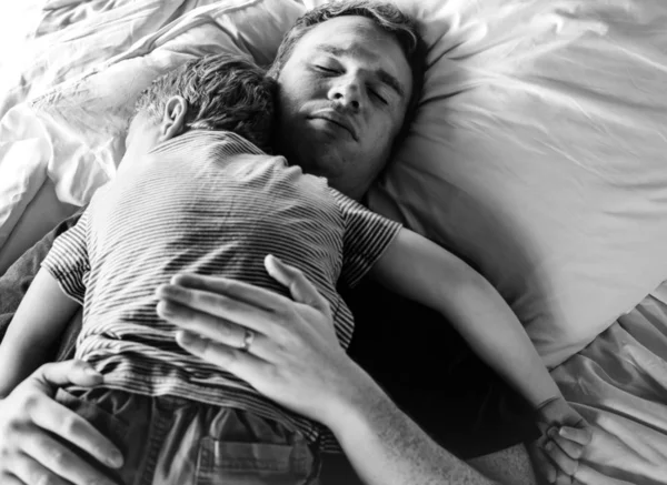 Тато Тримаючись Свого Сина Ліжку — стокове фото
