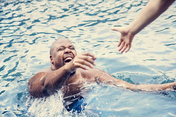 scared african american man being rescued while drowning